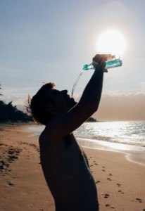 Ein Mann der in der Hitze Wasser trinkt