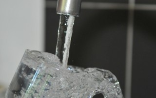 Trinkwasser aus der Leitung fließt in ein Glas